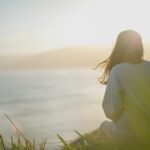 Woman sitting calmly and looking out at the sea