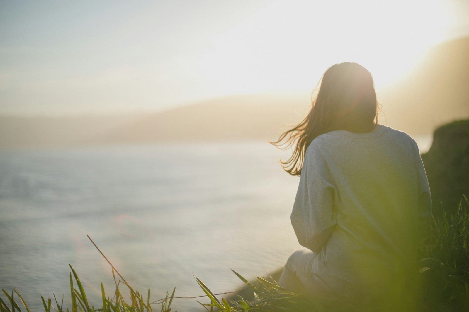 Woman sitting calmly and looking out at the sea