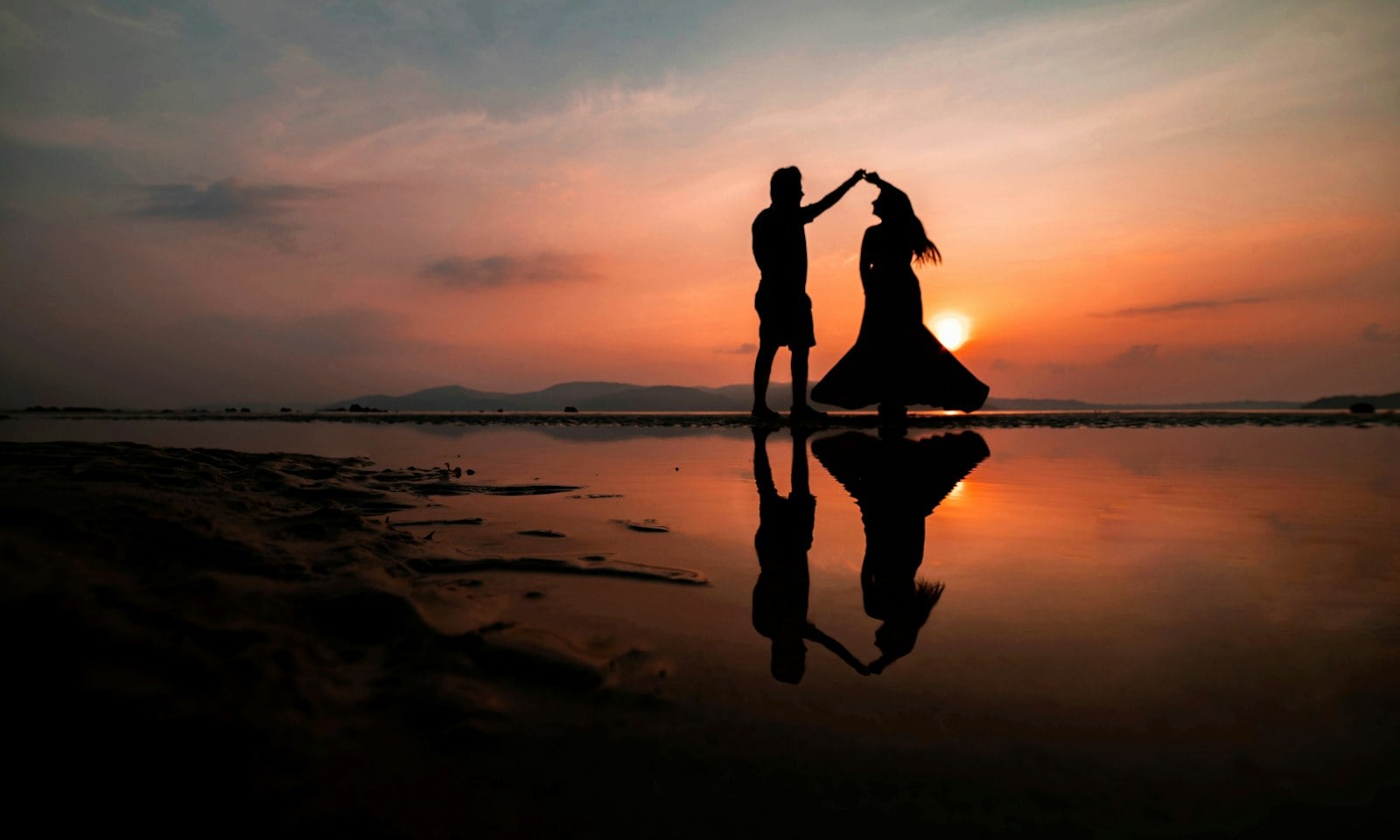 Silhouette of a couple dancing on the beach at sunset
